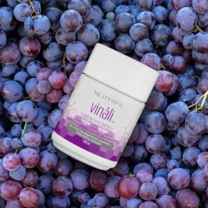 Vinali Nutrifii with vitamin C and grape seed extract against a background of grape clusters