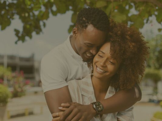 Image d'un couple souriant avec l'homme qui enlace sa femme