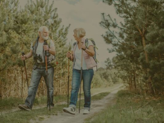 image d'un couple qui a la soixantaine marchant dans la nature