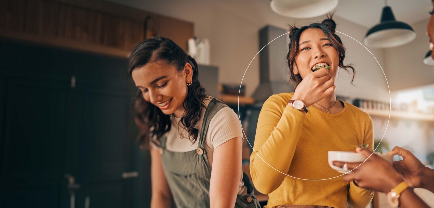Image de deux femmes sans une cuisine mangeant et préparant des plats équilibrés