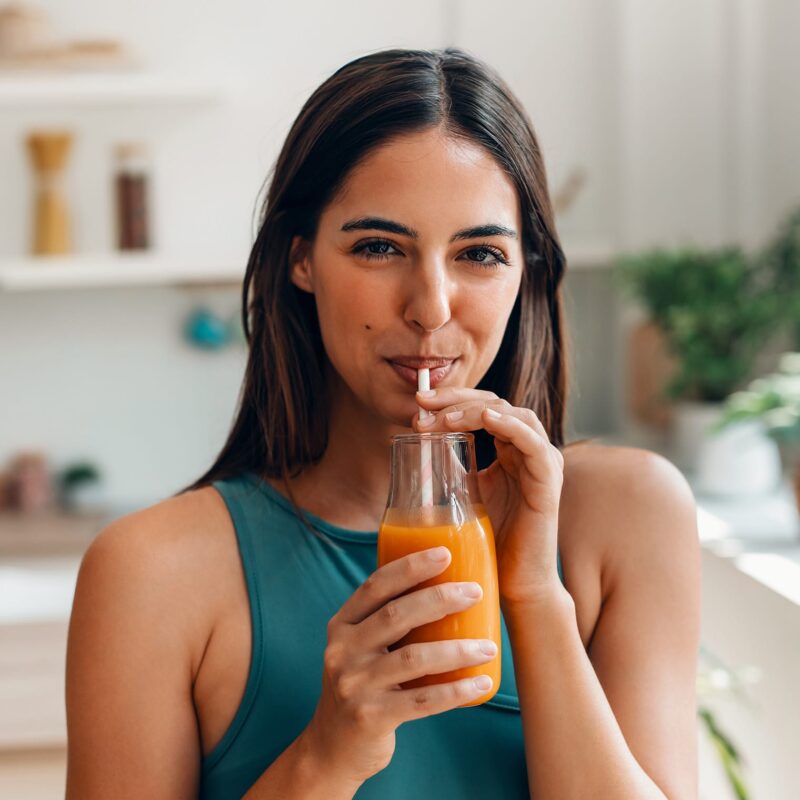Image d'une femme buvant dans un verre avec une paille le produit Glicotrol